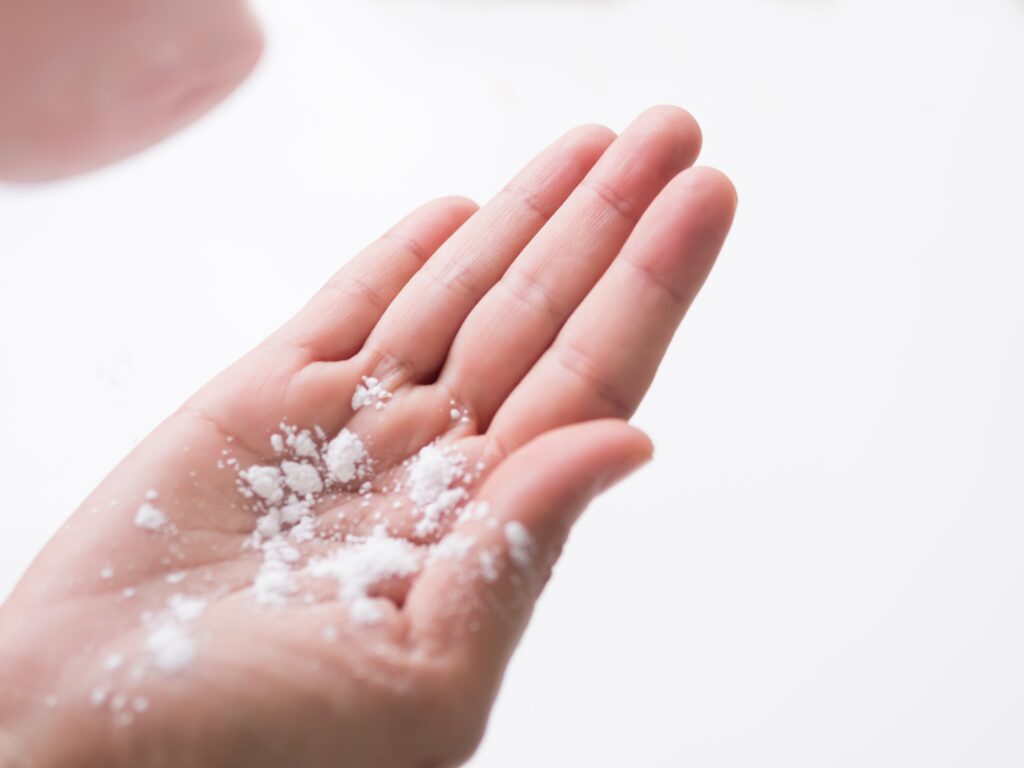 Talcum to Hand on white background,Baby Powder on Woman Hand Close Up